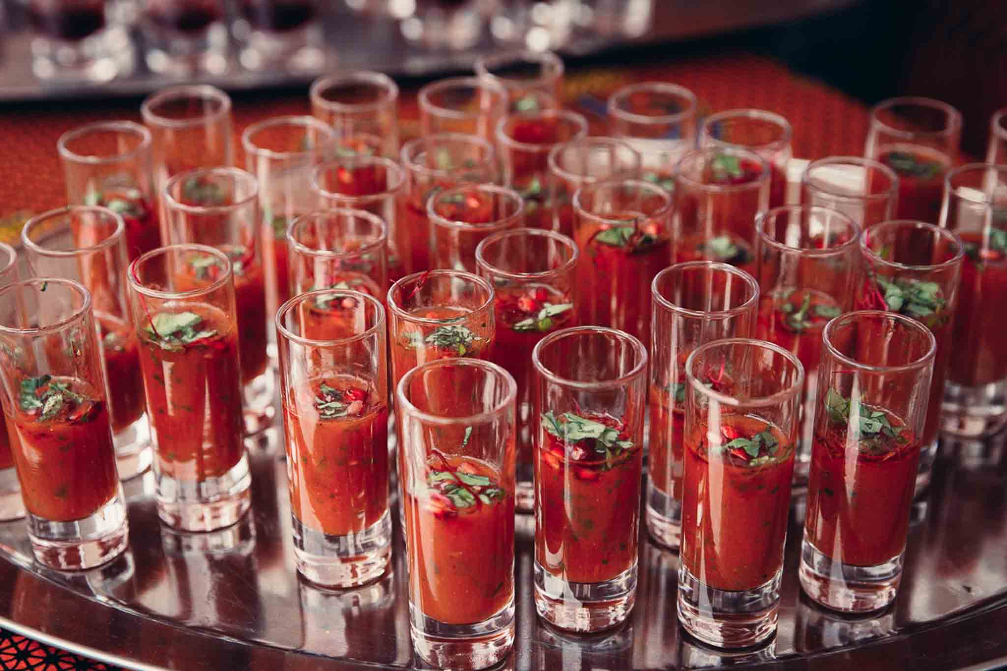 Een grote hoeveelheid bloody marys cocktails op een zilvere plakaat.