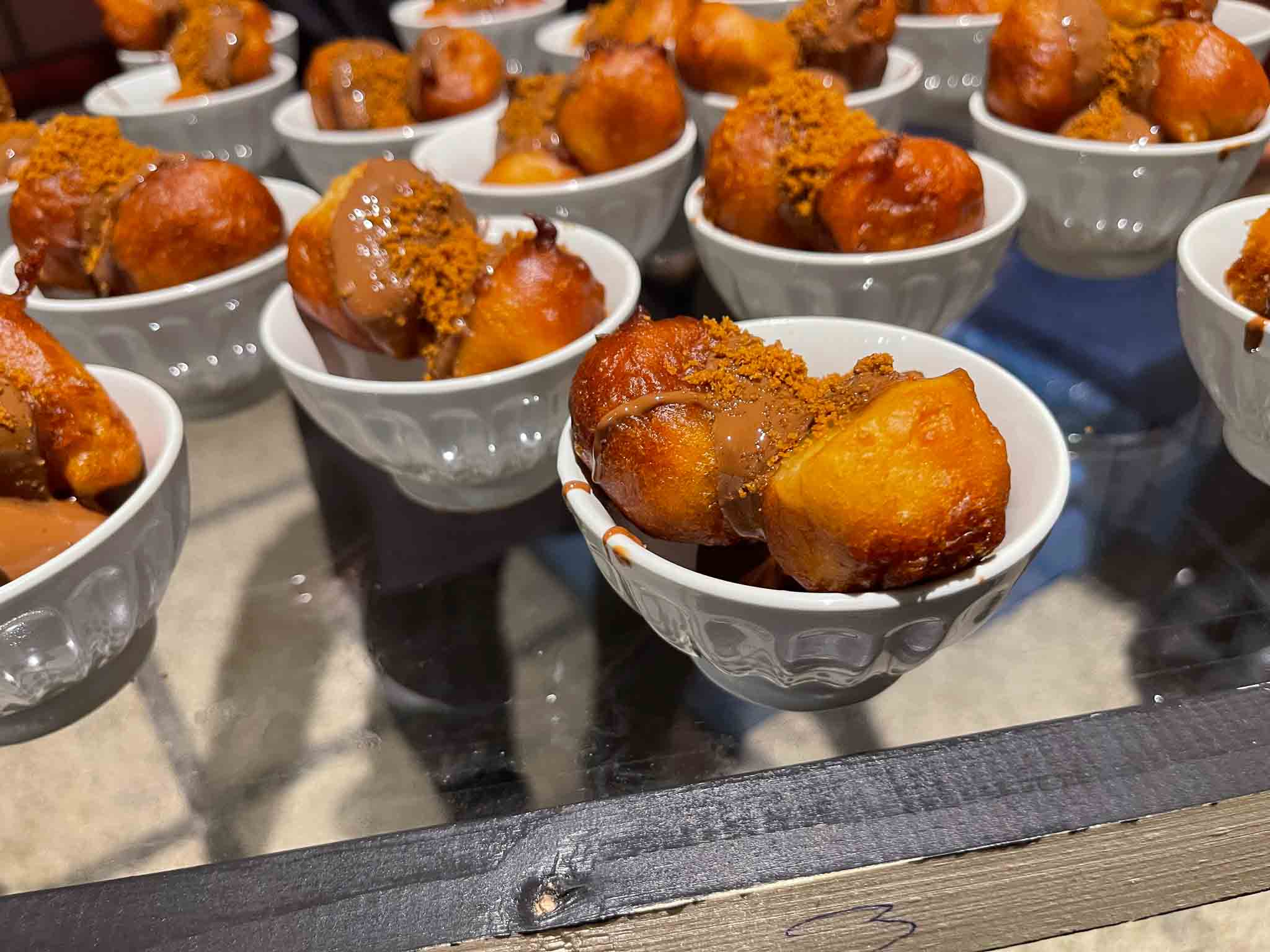 Wit kommetje met Griekse Loukoumades. Dit is een soort custardgebak in filodeeg.