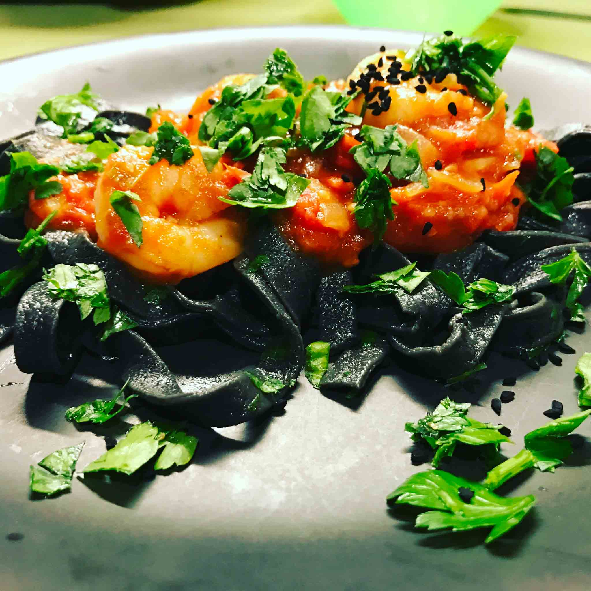 Zwarte pasta met garnalen en groenten.