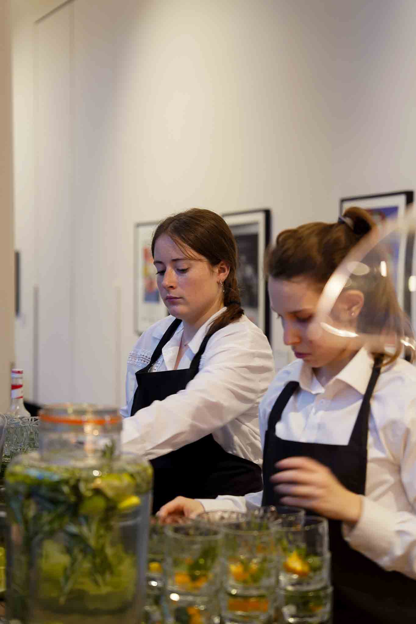 2 medewerksters maken drankjes klaar voor de klant.